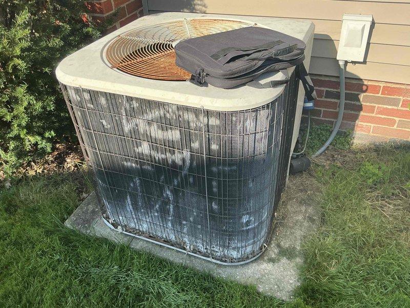 Conducted estimate for replacement of 23-year-old central air conditioning system at single-family residence. Evaluated existing outdoor condensing unit positioned on concrete pad adjacent to brick exterior with vinyl siding, noting age-related wear and end of serviceable life expectancy. Assessed indoor air handler components including ductwork, control panel, and condensate drain line configuration in mechanical space. Documented current system specifications and installation requirements through photographic survey to provide comprehensive replacement recommendations for complete cooling system upgrade.