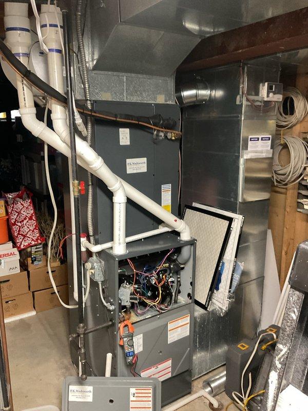 # HVAC Cooling Maintenance Summary

Completed comprehensive cooling system maintenance on residential HVAC unit located in basement utility area. Performed thorough inspection of air handler and furnace components with front access panel removed for detailed examination of electrical connections, control boards, and wiring terminals. All multicolored wire connections verified secure and properly terminated. Utilized digital multimeter to test electrical readings and verify proper voltage levels across system components. Attached manifold gauges to measure refrigerant pressures and confirm system is operating within manufacturer specifications. Inspected condensate drain lines (PVC piping) for proper drainage and verified no blockages present. Examined ductwork connections including flexible and rigid metal sections for secure attachment and proper sealing. Checked air handler unit and associated metallic ductwork for any signs of damage or deterioration. All components found to be func