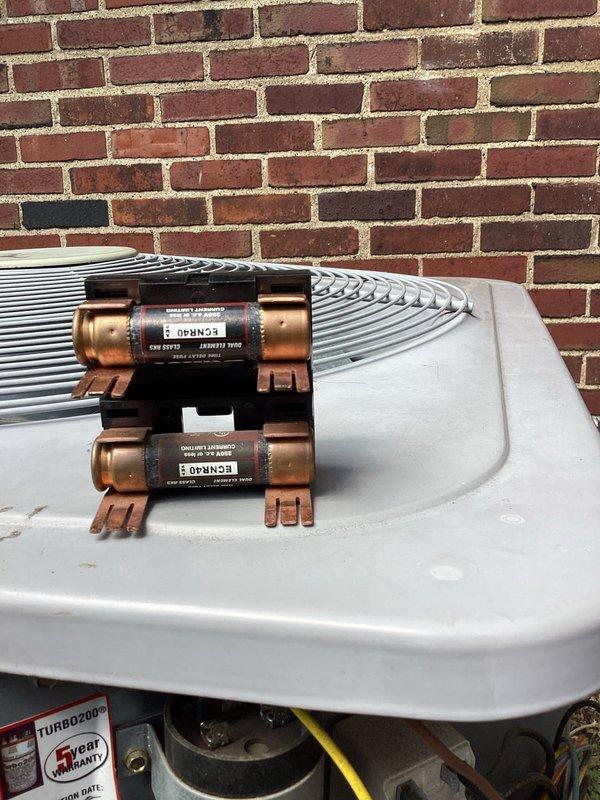 Performed routine cooling maintenance on a Unico high-velocity HVAC system. Accessed outdoor condensing unit with dual refrigerant filter driers mounted on copper lines and inspected interior air handler components in confined crawl space. Verified system operation with temperature readings showing proper cooling performance at 4.92 degrees, checked refrigerant lines, and confirmed all components functioning within normal parameters.