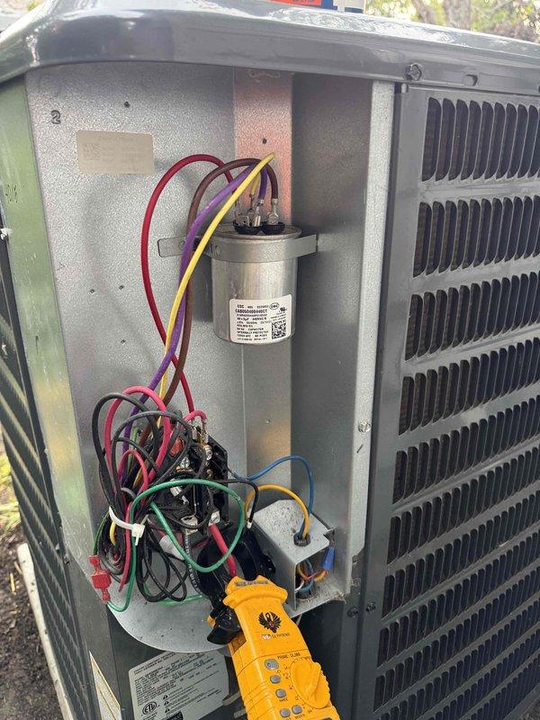 Completed comprehensive cooling system maintenance inspection on residential HVAC unit. Performed electrical diagnostics using digital multimeter to verify capacitor functionality, contactor operation, and proper voltage readings across all electrical components. All measurements indicated normal operating parameters with capacitor showing proper microfarad values and voltage within manufacturer specifications. Inspected condenser coil, heat exchanger, and internal wiring connections for signs of wear, corrosion, or deterioration—all components found in good working condition with secure terminal connections and proper wire routing. System tested and confirmed operational for continued cooling season performance.