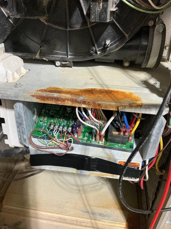 Responded to service call for non-functional thermostat. Upon arrival, inspected HVAC system control board and wiring connections after customer reported thermostat would not power on despite checking wiring and replacing batteries. Examined blower assembly, control board circuitry, and all wire terminations for potential issues causing loss of power to thermostat. Documented system condition including evidence of moisture exposure on internal components and verified all electrical connections to circuit board were secure.