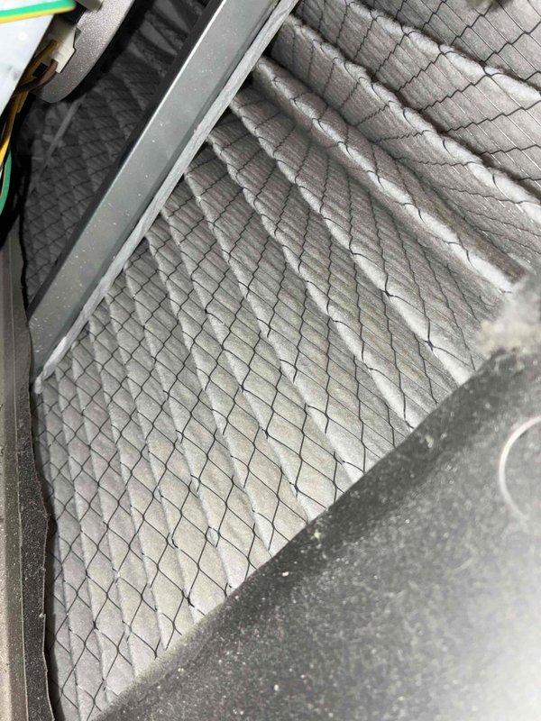# HVAC Cooling Maintenance Service

Completed comprehensive cooling system maintenance as part of ongoing preventive maintenance program. Performed thorough inspection of air handling unit components, including assessment of air filter condition and blower assembly operation. Filter exhibited heavy dust and debris accumulation across entire surface area, indicating need for replacement or cleaning to maintain proper airflow and system efficiency. Inspected squirrel cage blower wheel assembly, noting dust buildup on fan blades consistent with normal operation. Verified blower motor mounting and housing integrity within metal ductwork enclosure. All components photographically documented for service records.