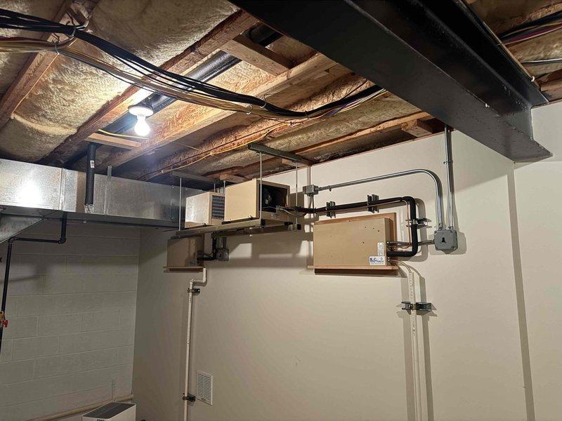 Responded to service call for yellow warning indicator on thermostat controlling one of three residential air conditioning systems installed approximately one year prior. Performed diagnostic evaluation of the affected outdoor condensing unit and corresponding indoor air handler to identify the source of the system alert. Upon inspection of both the exterior equipment positioned on gravel pad and the basement-mounted air handler with associated refrigerant lines and condensate drainage, no active cooling deficiencies or operational failures were detected. All refrigerant lines, electrical connections, and mechanical components appeared properly installed and functioning within normal parameters at time of service visit.