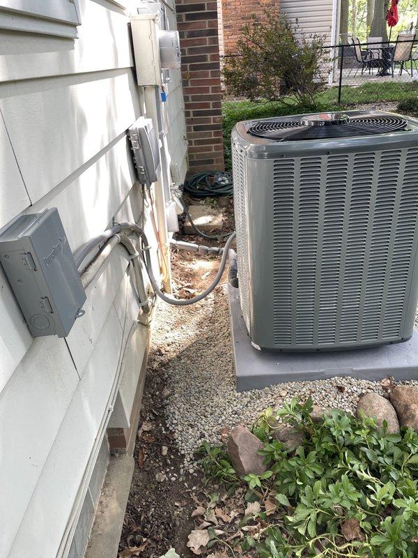 Completed full HVAC system installation including outdoor condensing unit positioned on concrete pad with proper electrical disconnect and conduit installation, refrigerant line sets secured to exterior wall with appropriate mounting brackets, and indoor furnace equipment installed in utility area with connected ductwork and carbon monoxide detector placement. System financed through service financing program with electrical panel work scheduled as final component to complete installation. All equipment properly positioned, connected, and prepared for final electrical connection and system startup upon completion of panel upgrade.