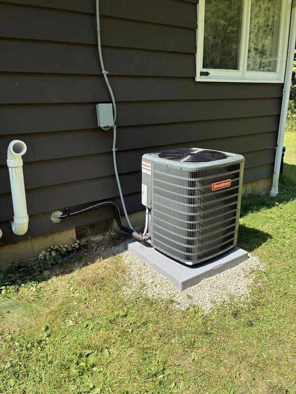 Completed installation of Goodman brand air conditioning system as add-on to existing HVAC setup, coordinated with same-day electrical work. Unit mounted on concrete pad with proper gravel base, all refrigerant lines, electrical conduit, and PVC drain line professionally installed and secured to exterior wall per manufacturer specifications. System tested and verified operational, full balance collected upon completion.