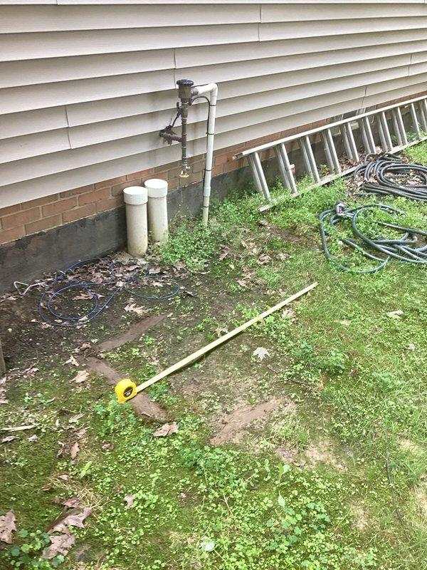 Conducted on-site assessment for residential backup generator installation. Evaluated existing natural gas meter and supply infrastructure, documenting current gas line configuration, meter capacity, and available connection points. Inspected exterior utility access areas and identified optimal placement zones for generator unit considering clearance requirements, fuel source proximity, and electrical service panel accessibility. Photographed gas meter assembly showing copper supply piping with visible oxidation and existing utility connections mounted on vinyl-sided structure with brick foundation. Assessed yard conditions and documented available space for generator pad installation and necessary utility routing.