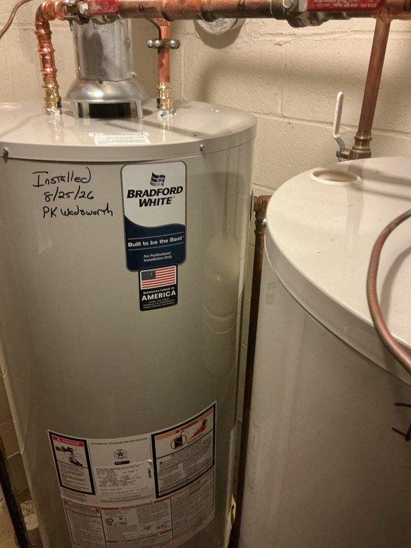Replaced two 50-gallon Bradford White residential water heaters in utility room. Installation included proper copper piping connections with shut-off valves, brass fittings, expansion tank integration, and code-compliant galvanized flue venting for both units.