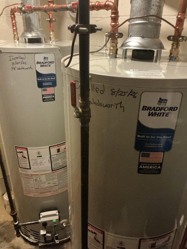 Replaced two 50-gallon Bradford White residential water heaters in utility room. Installation included proper copper piping connections with shut-off valves, brass fittings, expansion tank integration, and code-compliant galvanized flue venting for both units.