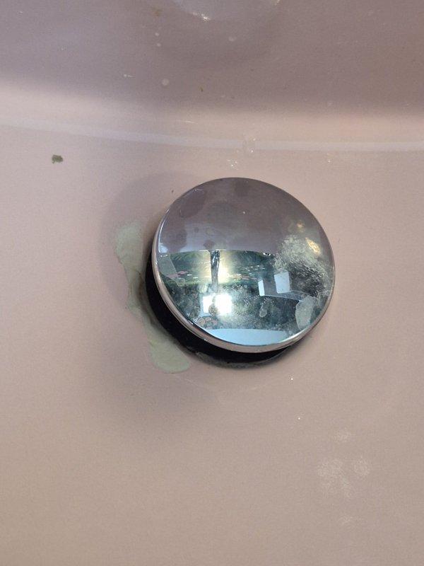 Returned to property to assess reported crack or chip in sink basin. Upon inspection, photographed and documented the sink drain area, noting minor discoloration and residue buildup around the chrome drain cover but no structural damage or cracks present in the porcelain fixture. Confirmed sink integrity is intact and requires no repair at this time.