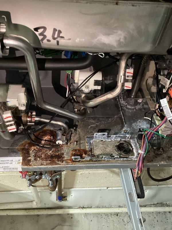 Responded to service call for tankless water heater system that would not power on despite customer attempts to reset and unplug the unit. Upon inspection, discovered significant corrosion and rust damage to the drain pan and internal components, along with evidence of water staining and moisture exposure throughout the system. Performed diagnostic evaluation of electrical connections, wiring, and mechanical components to identify the root cause of the power failure and assessed the overall condition of the unit for necessary repairs or replacement recommendations.