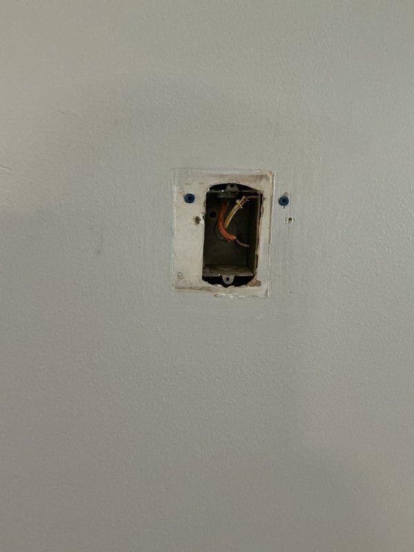 Assessed existing through-the-wall hydronic fan coil unit in condo showing extensive corrosion and active leaking, with no visible manufacturer markings or model identification. Documented current two-wire thermostat configuration connected to building's central boiler system for heating and cooling switchover. Provided replacement equipment recommendations and thermostat compatibility options for the hydronic system, including photographic documentation of deteriorated piping, water-damaged wall surfaces, and existing control wiring for estimate preparation.