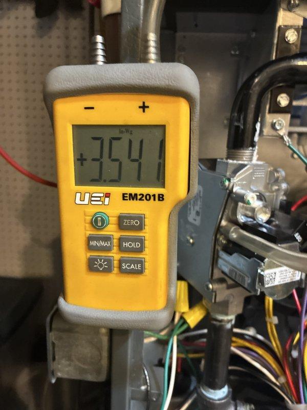 Completed warranty replacement installation of a Goodman 96% AFUE high-efficiency furnace. Installed new unit with proper venting using white PVC piping, connected all electrical components, and verified system operation with digital multimeter showing proper voltage readings at 354.4V EMF. All ductwork connections secured, condensate drainage lines properly routed, and unit tested for safe operation.