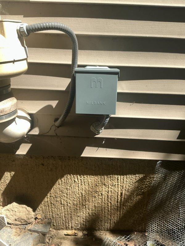 Installed two exterior GFCI-protected outlets with new Milbank weatherproof enclosure mounted on building siding. Ran gray flexible conduit from panel box to exterior location, added dedicated circuit breakers to main electrical panel, and completed all necessary wiring to code specifications for outdoor receptacles.