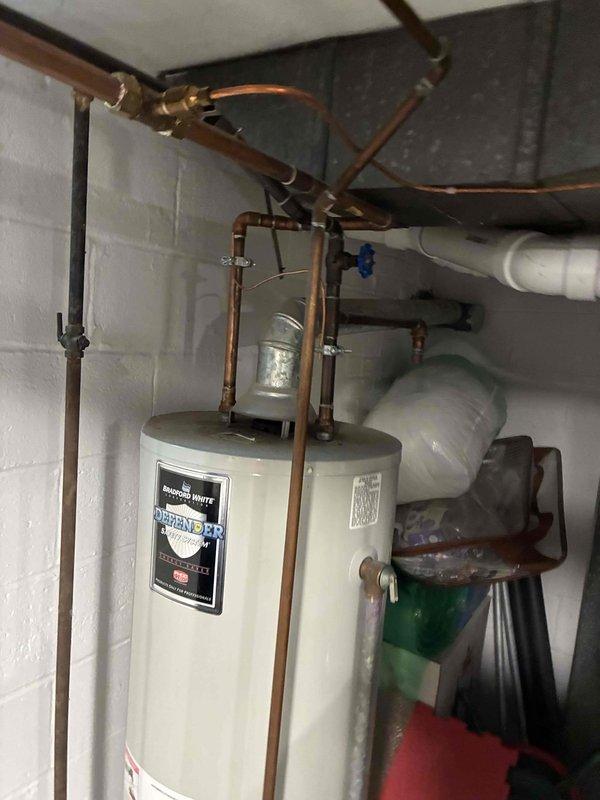 Responded to reported concern of possible carbon monoxide issue from tanked water heater. Upon arrival, performed comprehensive safety inspection of Bradford White tanked water heater and surrounding mechanical systems. Conducted visual examination of water heater unit, including manufacturer label verification, copper piping connections, and all valving at top of unit. Inspected flue pipe configuration and venting system to ensure proper draft and exhaust. Examined all gas connections, supply lines, and shut-off valves for leaks or deterioration. Verified proper clearances around unit and checked for signs of backdrafting or incomplete combustion. Assessed condition of temperature and pressure relief valve and discharge piping. Reviewed overall installation compliance with safety standards, including proper ventilation in mechanical room. No immediate carbon monoxide hazards or safety concerns identified during inspection. All plumbing connections, copper lines, and PVC drainage syste