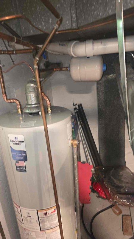 Responded to reported concern of possible carbon monoxide issue from tanked water heater. Upon arrival, performed comprehensive safety inspection of Bradford White tanked water heater and surrounding mechanical systems. Conducted visual examination of water heater unit, including manufacturer label verification, copper piping connections, and all valving at top of unit. Inspected flue pipe configuration and venting system to ensure proper draft and exhaust. Examined all gas connections, supply lines, and shut-off valves for leaks or deterioration. Verified proper clearances around unit and checked for signs of backdrafting or incomplete combustion. Assessed condition of temperature and pressure relief valve and discharge piping. Reviewed overall installation compliance with safety standards, including proper ventilation in mechanical room. No immediate carbon monoxide hazards or safety concerns identified during inspection. All plumbing connections, copper lines, and PVC drainage syste