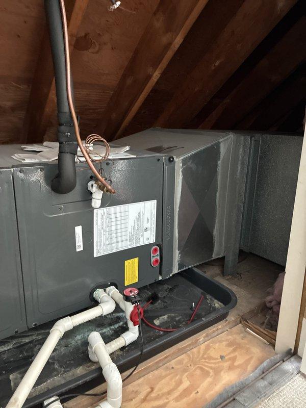 Completed HVAC system estimate for heat pump replacement at residential property. Accessed existing air handler unit located in attic crawl space to assess installation requirements and provide replacement options. Unit features horizontal configuration with copper refrigerant lines, PVC condensate drainage system with multiple shut-off valves, black drain pan, and electrical disconnect. Documented current equipment specifications, installation access points, and existing infrastructure including ductwork connections and clearance space for future replacement work.