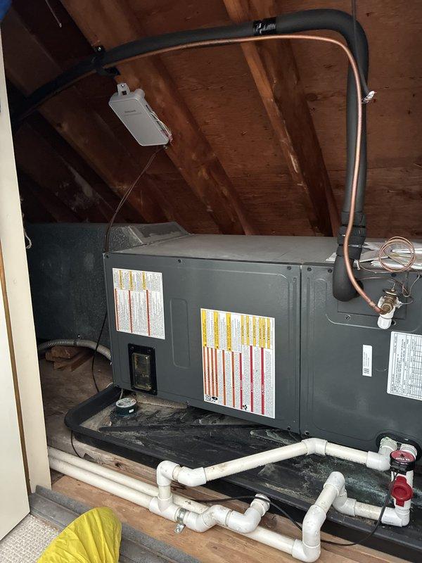 Completed HVAC system estimate for heat pump replacement at residential property. Accessed existing air handler unit located in attic crawl space to assess installation requirements and provide replacement options. Unit features horizontal configuration with copper refrigerant lines, PVC condensate drainage system with multiple shut-off valves, black drain pan, and electrical disconnect. Documented current equipment specifications, installation access points, and existing infrastructure including ductwork connections and clearance space for future replacement work.