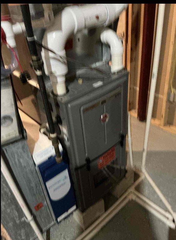 Conducted on-site evaluation and provided furnace replacement options for residential heating system. Assessed existing gray metal furnace unit installed in basement utility area with white PVC exhaust venting system and documented current equipment configuration including associated water heater. Reviewed electrical service panel requirements and photographed existing installation to support equipment replacement recommendations and ensure proper system specifications for future installation.