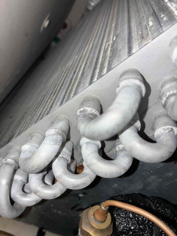 # HVAC Cooling Maintenance - 10+ Years Old Unit

Performed comprehensive preventive maintenance on aging cooling system. Upon inspection, discovered significant frost and ice accumulation on refrigerant lines and evaporator coils, indicating potential airflow restriction or refrigerant charge issues. Documented electrical connections and wiring configuration, noting multiple wire terminations at junction block with proper color coding and secure cable management via zip ties. Inspected brass fittings and copper refrigerant line connections for integrity. Captured photographic documentation of frosted coil conditions and electrical component layout for maintenance records. System evaluated under MVP maintenance program protocol.