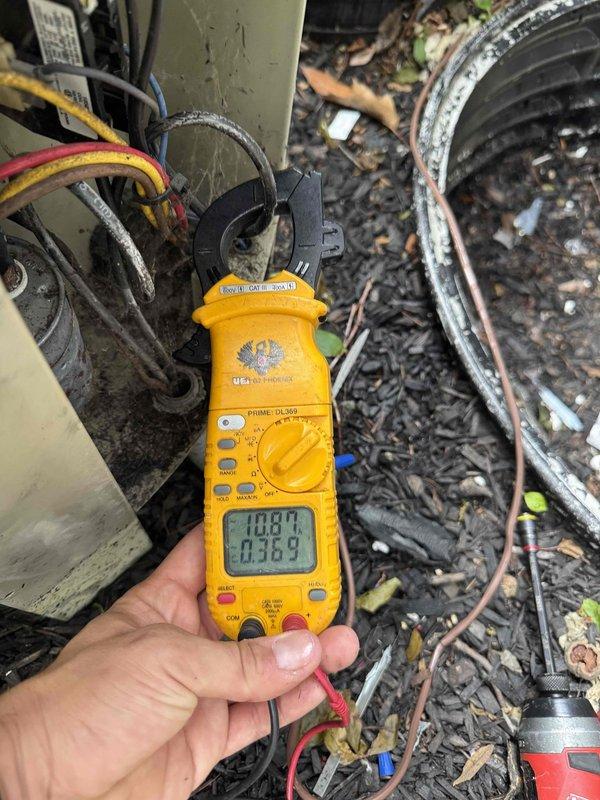 # HVAC Service Completed

Responded to no cooling complaint on 30-year-old air conditioning system located in basement. Upon arrival, performed diagnostic evaluation of outdoor condensing unit to determine cause of cooling failure.

Conducted electrical testing using digital clamp meter to measure voltage and amperage at outdoor unit. Tested multiple circuits including compressor and condenser fan motor connections. Readings indicated electrical supply issues affecting system operation. Measured line voltage at 100.8V and low amperage draw of 0.363A, confirming inadequate power delivery to compressor circuit.

Inspected all electrical connections at outdoor unit terminal block. Found deteriorated wire connections with signs of age-related degradation. Removed old wire nuts and separated corroded conductors. Stripped back damaged wire insulation to expose clean copper conductors. Reconnected power wiring using new wire nuts, ensuring proper wire-to-wire contact and secure mechanical con