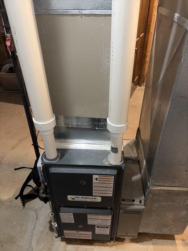 Completed preventive maintenance service on two cooling systems. During inspection, discovered severe frost accumulation and ice buildup on supply ductwork in attic space, with temperature reading of -3.0°F indicating excessive cooling and potential refrigerant or airflow issues. Noted damaged duct insulation with torn foil facing exposing fibrous material, which may contribute to condensation problems and reduced system efficiency. Inspected furnace unit and associated HVAC equipment in mechanical room, verified proper installation of PVC venting and metal ductwork connections. Both systems evaluated for seasonal cooling performance and operational safety.