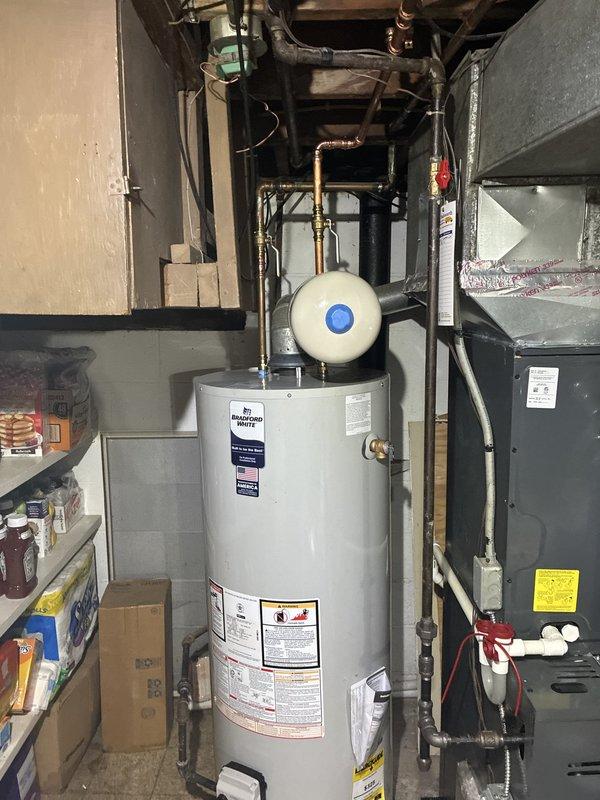 Completed installation of 50-gallon residential water heater with expansion tank in utility room. Unit was properly connected to existing copper supply lines, with all piping, fittings, and safety devices installed to code specifications, ensuring reliable hot water delivery for the home.