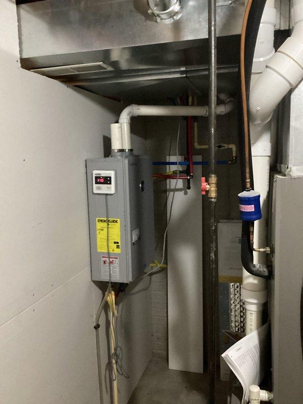Responded to service call for tankless water heater not maintaining consistent hot water temperature. Upon arrival, inspected wall-mounted tankless unit and associated plumbing connections in mechanical room. Evaluated digital display panel for error codes and examined PVC venting system, copper supply lines, and PEX distribution piping. Assessed water flow, gas supply connections, and pressure readings at various points throughout the system. Documented existing installation configuration including water filtration equipment and multi-zone piping distribution network for diagnostic purposes.