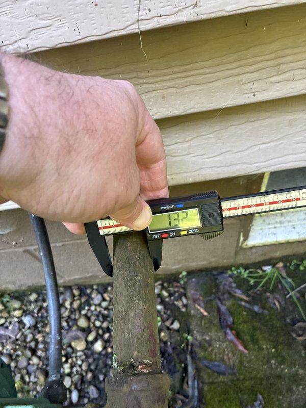 Conducted on-site evaluation for HVAC system replacement. Performed precise measurements of existing refrigerant line set using digital calipers, documenting pipe diameter at 12.7mm for proper equipment sizing and compatibility assessment. Assessed condition of outdoor unit components, noting significant corrosion and weathering on refrigerant lines and compressor housing, indicating need for complete system replacement. Provided customer with heat pump and air handler replacement options based on existing installation accessibility and equipment specifications.