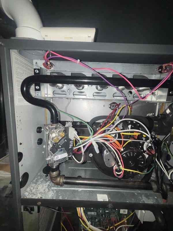 # HVAC First Year Cooling Maintenance Completed

Performed comprehensive first-year cooling maintenance on residential HVAC system. Conducted thorough inspection of furnace and control system components, documenting internal conditions of both the main heating unit and electronic control assembly. Examined circuit boards, wiring connections, and electrical components within the control panel, verifying proper connections and component integrity. Inspected furnace interior including gas valves, burner assembly, blower motor, ventilation piping, and associated wiring harnesses. All components found to be in operational condition with normal wear patterns. System maintenance completed as scheduled with photographic documentation of equipment condition for service records.