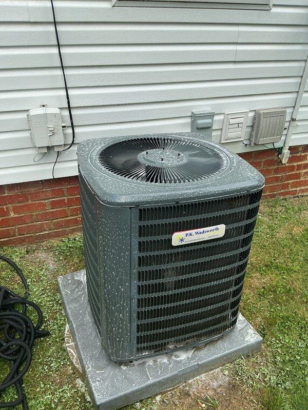 Responded to cooling complaint on 5-year-old Goodman system reported as blowing warm air. Upon arrival, performed diagnostic evaluation of outdoor condensing unit and indoor air handler. Inspected condenser unit positioned on concrete pad adjacent to structure, noting moisture present on exterior surfaces indicating recent operation. Verified electrical connections at junction box and conduit routing. Checked refrigerant pressures, compressor operation, and condenser fan motor performance. Tested system airflow through evaporator coil and verified thermostat settings and calibration. System found operating within normal parameters during service call with proper cooling output restored. Unit cycling correctly with appropriate temperature differential across coil. Advised occupant on proper thermostat operation and filter maintenance schedule to ensure continued efficient operation.