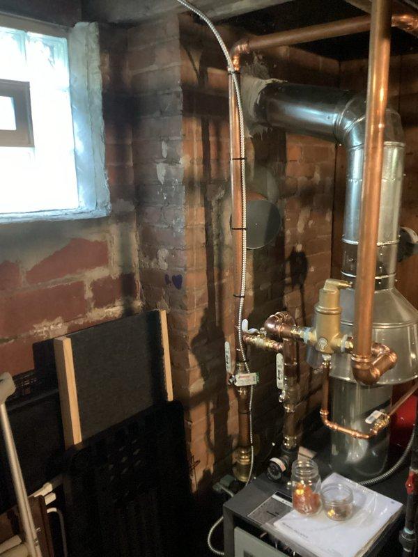 Responded to failed boiler inspection due to critical electrical wiring violations in basement mechanical room. Line voltage wiring was improperly connected to water line, and low voltage wiring was incorrectly attached to gas line, creating serious safety hazards. Documented existing conditions with photographs showing the tankless water heater installation, copper piping network, electrical conduit routing, and control panel configuration to support warranty claim and code compliance requirements.