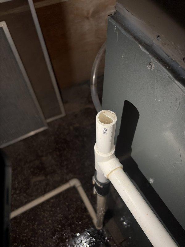 Completed comprehensive cooling system tune-up and performance evaluation. Verified proper operation of condensate drainage system with PVC discharge line and confirmed secure mounting hardware. Measured and documented system temperatures, recording 77.7°F reading to assess cooling performance and refrigerant charge levels.