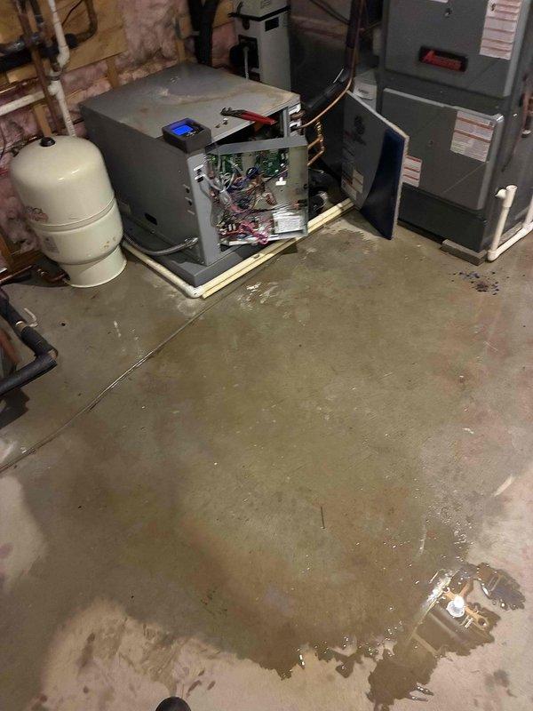 Responded to emergency service call for non-operational geothermal system with water overflow condition causing flooding in mechanical room. Upon arrival, found extensive water accumulation on basement floor surrounding geothermal heat pump equipment. Performed diagnostic testing using digital multimeter to assess system controls and electrical components. Opened access panels on air handler unit to inspect internal circuitry, control boards, and wiring for water damage or electrical faults. Identified source of water overflow and addressed flooding issue to restore system operation and prevent further water damage to mechanical equipment and basement area.