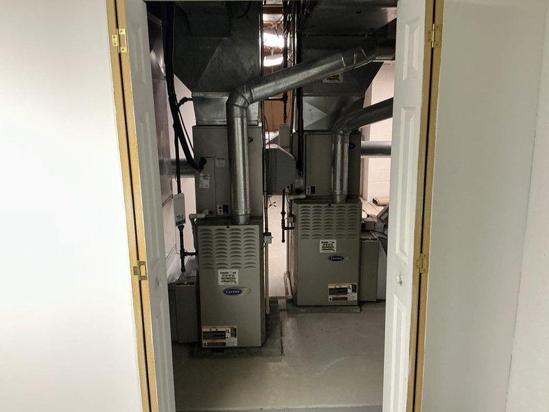 Conducted on-site assessment of existing dual-zone HVAC system in basement mechanical room to provide replacement options for aging equipment. Documented current configuration including two furnace units with associated ductwork, evaluated system layout and spatial constraints, and photographed existing installation to develop comprehensive replacement proposals for the customer's consideration.