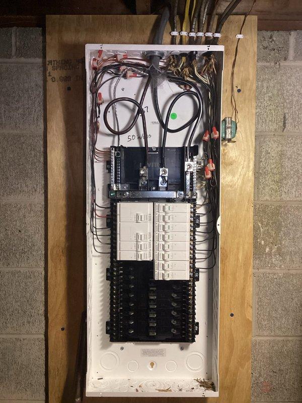 Completed a comprehensive 100-amp electrical service upgrade involving replacement of both the exterior meter panel and interior main distribution panel. Installed new meter base with dual metering capability, main disconnect breaker rated at 50kA interrupting capacity, and organized circuit breaker distribution with proper color-coded wiring throughout. Ran 1½-inch PVC conduit for service entrance conductors, established proper grounding and bonding connections, and ensured all components met current NEC standards for residential electrical service installations.
