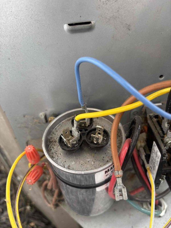 Completed routine HVAC cooling maintenance inspection on residential system. Inspected and photographed capacitor connections and wiring within the condensing unit, noting dust accumulation on components but confirming proper electrical connections remain secure. Performed moisture detection testing in attic space near air handler using pinless moisture meter to verify no water intrusion or condensate issues present in insulation or surrounding structure.