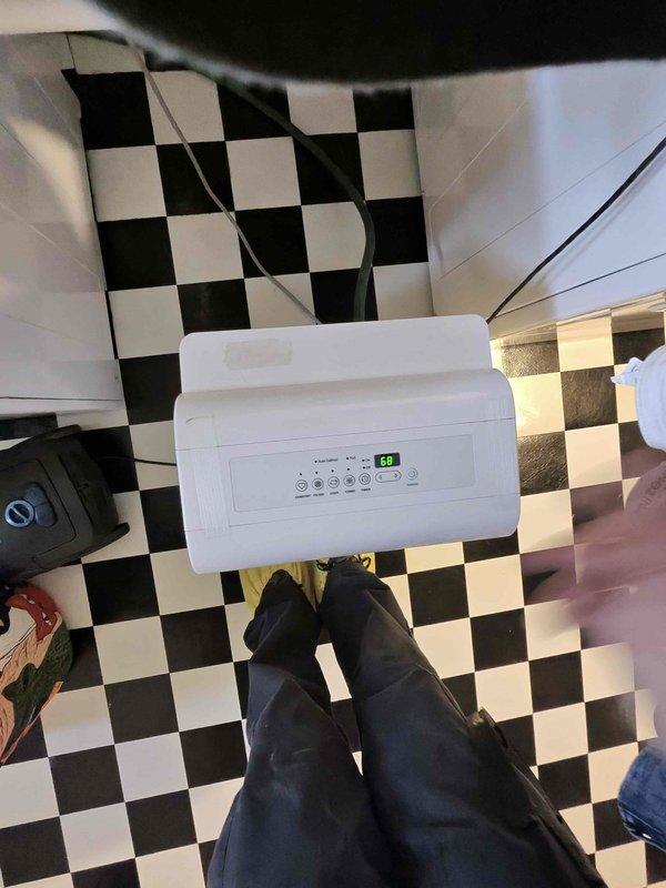 Responded to water leak complaint on 11-year-old Amana AC unit with water present on laundry room floor. Upon inspection, discovered evaporator coil heavily contaminated with dust and debris accumulation, particularly on left section of cooling fins, causing restricted airflow and drain pan overflow. Cleaned evaporator coil fins, cleared primary condensate drain line, verified proper drainage, and tested system operation to confirm resolution of leak issue.