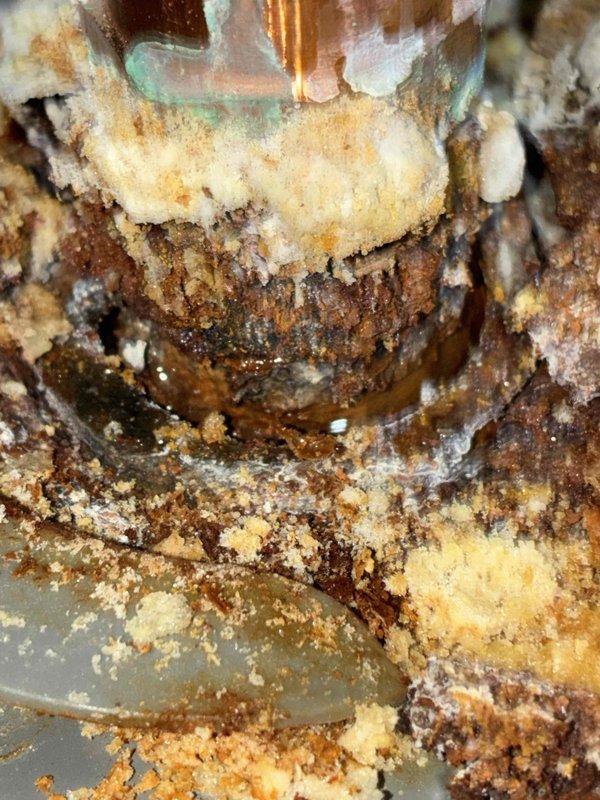 Completed scheduled preventive maintenance on residential furnace system as part of recurring service plan. Inspection revealed significant corrosion and mineral deposits on gas manifold connections and fuel delivery components, indicating moisture intrusion and potential combustion efficiency concerns. Documented equipment condition with photographic evidence showing oxidation on metallic fittings, brownish discoloration on fuel rail assembly, and severe mineral buildup at pipe junctions requiring monitoring for future remediation.