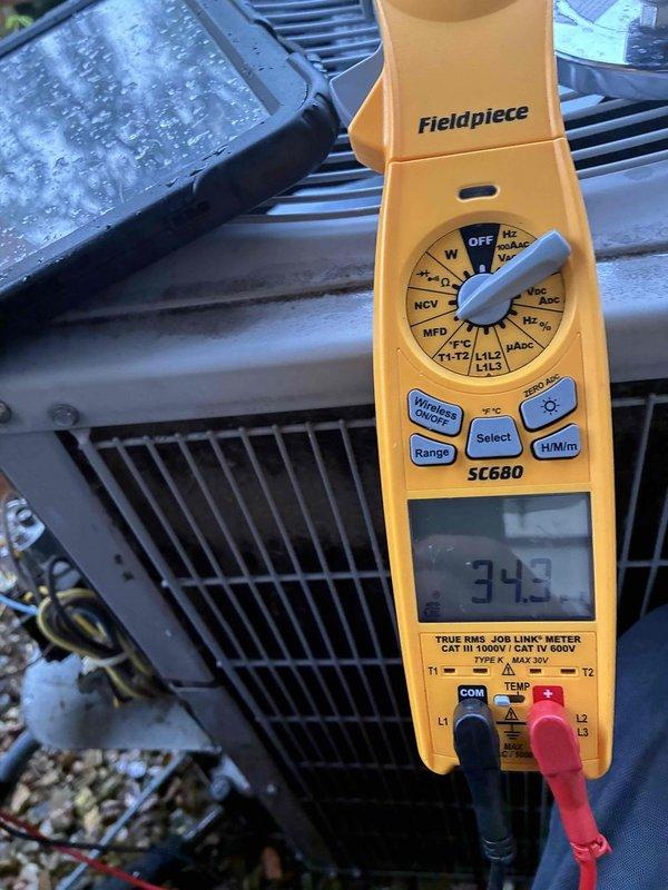 Responded to service call for Carrier air conditioning unit experiencing intermittent condenser fan operation. Upon arrival, performed diagnostic testing of the outdoor condenser unit using digital multimeter. Measured capacitor microfarad reading of 21 MFD, which indicated capacitor failure as the original specification was significantly higher. Further testing confirmed voltage readings of 34.3 volts at the fan motor terminals. Diagnosed failed run capacitor as root cause of condenser fan shutting off prematurely. Replaced defective dual run capacitor with properly rated OEM replacement part. Verified correct microfarad ratings for both compressor and fan motor circuits. Tested system operation through complete cooling cycle to ensure condenser fan maintained continuous operation without interruption. System restored to normal operating condition with proper airflow across condenser coil.