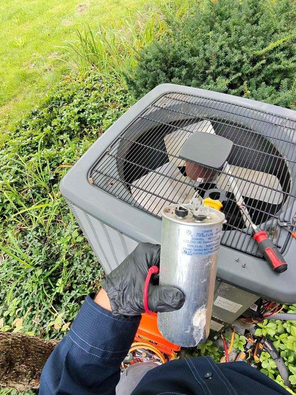 Responded to service call for air conditioning system not cooling properly due to reported coil leak. Upon inspection, diagnosed failed capacitor on outdoor condensing unit. Removed defective capacitor and installed replacement component. System tested and verified operational with proper cooling function restored.