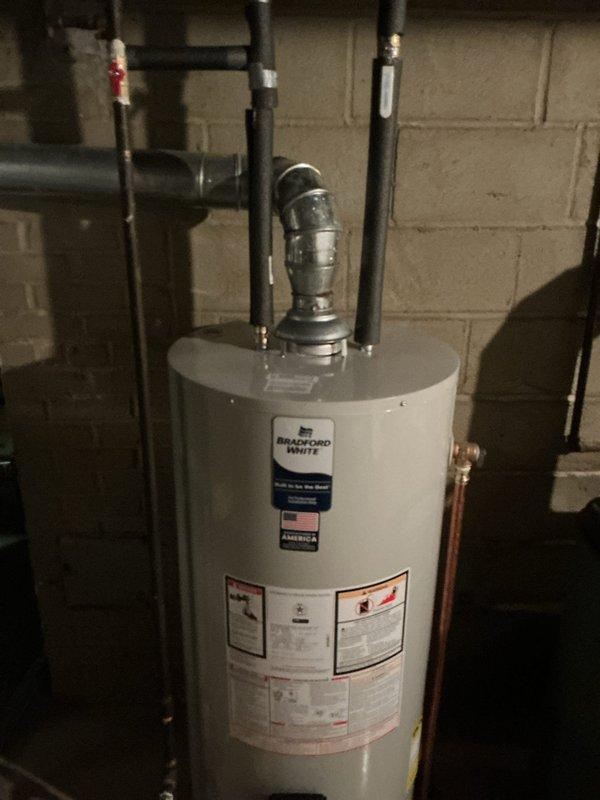 Responded to reported leak under gas water heater with visible water accumulation. Upon arrival, inspected Bradford White gas water heater unit and surrounding plumbing connections. Identified source of leak, performed necessary repairs to stop water discharge, and verified all connections were secure and functioning properly. Unit tested and confirmed operational with no further leakage detected.