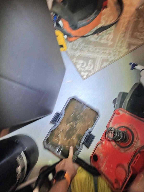 Responded to water accumulation beneath air handler unit in basement. Upon inspection, discovered heavy frost buildup on evaporator coils indicating restricted airflow or low refrigerant charge. Collected standing water from drain pan and documented frozen coil condition with photos for customer records.