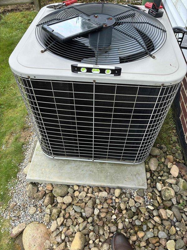 Returned to site to assess and verify levelness of outdoor condensing unit following previous re-leveling service. Confirmed unit is properly leveled using precision level tool on multiple surfaces of the equipment. Inspected mounting bracket installation used during leveling procedure and verified structural integrity and proper support. Addressed customer concerns regarding gravel placement around concrete pad and equipment base. Unit operating within normal parameters with secure positioning on pad.