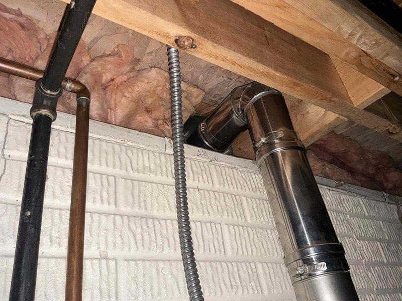 Completed installation of a 50-gallon power vent hot water heater in the mechanical space. The new unit was properly positioned, vented through the existing infrastructure with appropriate metallic ductwork and power vent assembly, and all gas and water connections were secured and tested for safe operation.