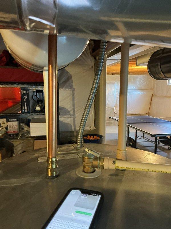 Responded to service call for leaking hot water tank. Upon arrival, inspected the tanked water heater and surrounding area in basement utility space. Confirmed active leak with visible water damage on concrete floor beneath unit. Documented copper supply piping, brass fittings, and flexible conduit connections. Assessed extent of water accumulation on floor and verified leak source from water heater tank. Collected diagnostic fee and photographed conditions for service documentation.