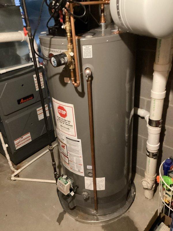 Conducted on-site assessment for tankless water heater installation to replace existing conventional storage tank water heater. Evaluated current setup including Rheem Performance series tank water heater, existing copper supply and return plumbing, expansion tank configuration, and available utility connections. Photographed mechanical room layout documenting water heater location adjacent to Amana furnace unit, existing pipe routing, electrical service availability, gas line access, and venting arrangement with current PVC exhaust system. Assessed space requirements and clearances needed for tankless unit installation, reviewed necessary modifications to existing plumbing infrastructure including potential rerouting of copper supply lines and installation of isolation valves. Documented current system specifications to prepare comprehensive quote for tankless conversion project.