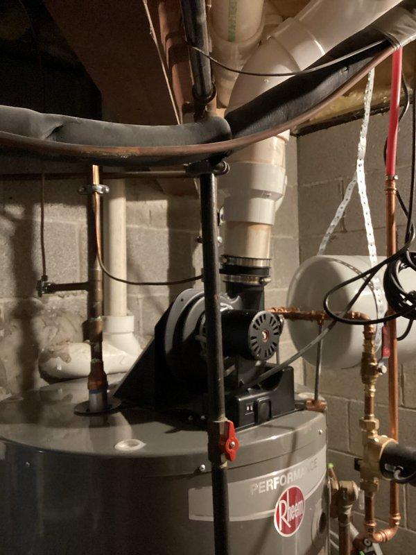 Conducted on-site assessment for tankless water heater installation to replace existing conventional storage tank water heater. Evaluated current setup including Rheem Performance series tank water heater, existing copper supply and return plumbing, expansion tank configuration, and available utility connections. Photographed mechanical room layout documenting water heater location adjacent to Amana furnace unit, existing pipe routing, electrical service availability, gas line access, and venting arrangement with current PVC exhaust system. Assessed space requirements and clearances needed for tankless unit installation, reviewed necessary modifications to existing plumbing infrastructure including potential rerouting of copper supply lines and installation of isolation valves. Documented current system specifications to prepare comprehensive quote for tankless conversion project.