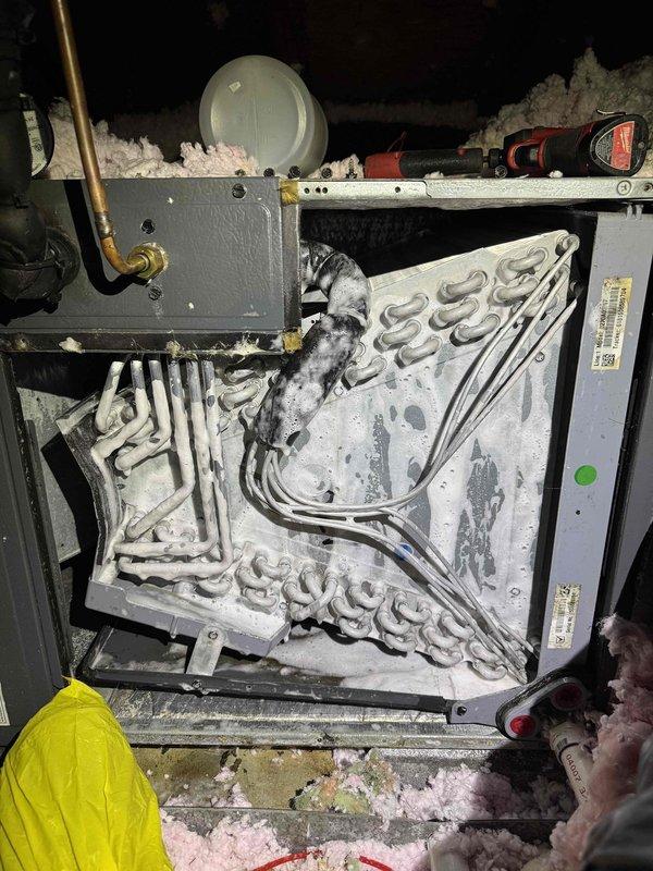 # HVAC Evaporator Coil Cleaning and Drain Maintenance

Responded to service call for HVAC system maintenance. Upon inspection, found evaporator coil with significant dust accumulation and heavy ice/frost buildup covering the serpentine refrigerant tubing, indicating restricted airflow and potential drainage issues. 

Performed comprehensive evaporator coil cleaning to remove dust, debris, and frost accumulation from all accessible surfaces of the heat exchanger assembly. Cleared ice buildup from coil surfaces to restore proper heat transfer efficiency. Cleaned condensate drain system and installed drain tabs to prevent algae growth and maintain clear drainage pathway. 

Verified proper airflow through coil assembly and confirmed condensate drainage functioning correctly. System restored to normal operating condition with improved heat exchange efficiency and preventative maintenance measures in place.