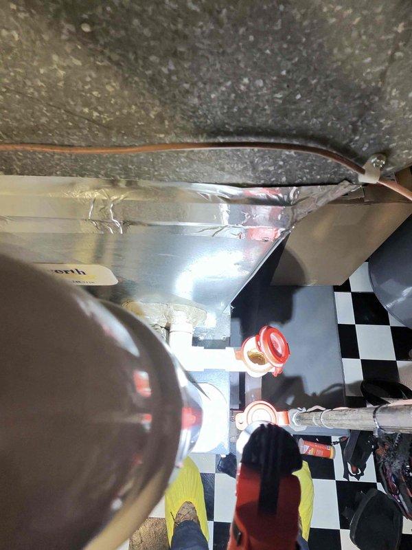 Responded to recurring water leak complaint on 11-year-old Amana AC unit located in garage. Inspected evaporator coil, drain pan, and condensate drainage system following two previous service visits. Found condensate drain line obstruction and improper pitch causing water to back up into basement/laundry room area. Cleared blockage, adjusted drain line slope, and verified proper drainage flow. Tested system operation through complete cooling cycle to confirm leak resolution.