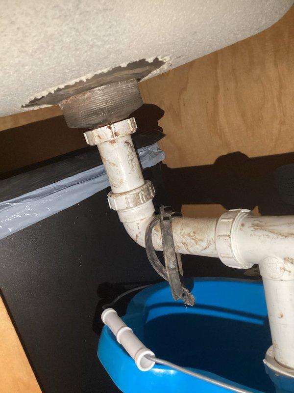 Responded to service call for disconnected kitchen sink drain assembly. Upon inspection, found the P-trap connection beneath the kitchen sink had separated, causing the drain line to become detached from the sink basin. Reconnected and properly secured all PVC pipe fittings and coupling nuts in the P-trap assembly. Verified all connections were tight and leak-free, then tested the drain system to ensure proper water flow and drainage function.
